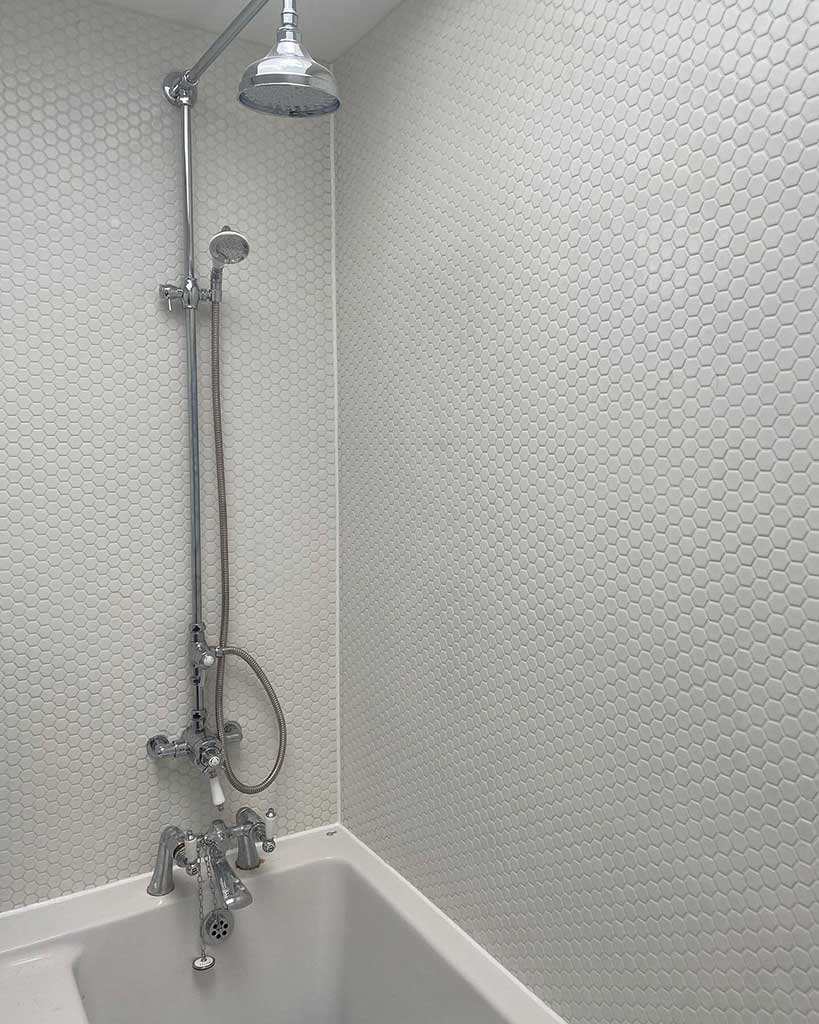 Exposed shower over bath, textured tiles