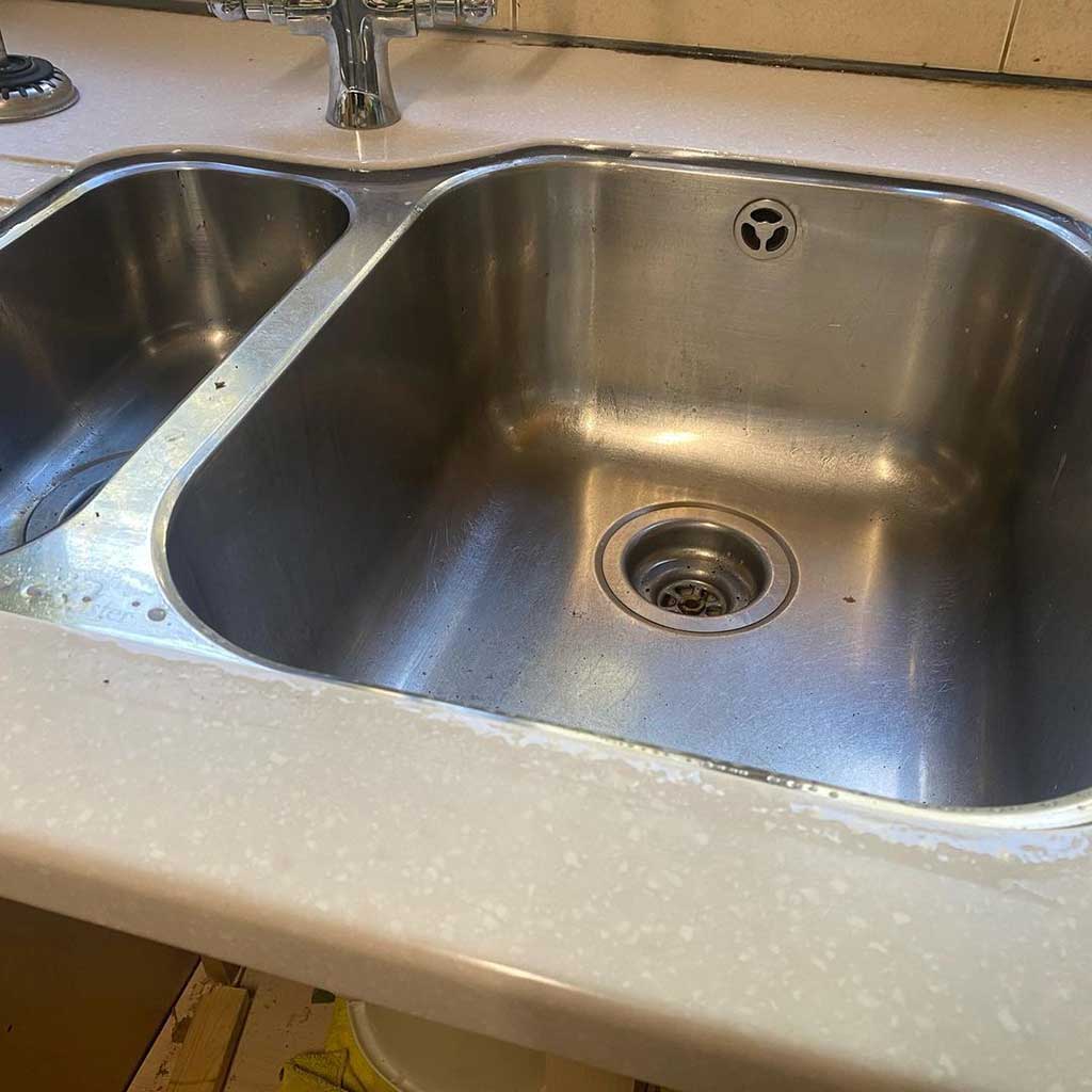 Sealed edge where a stainless sink meets the worktop