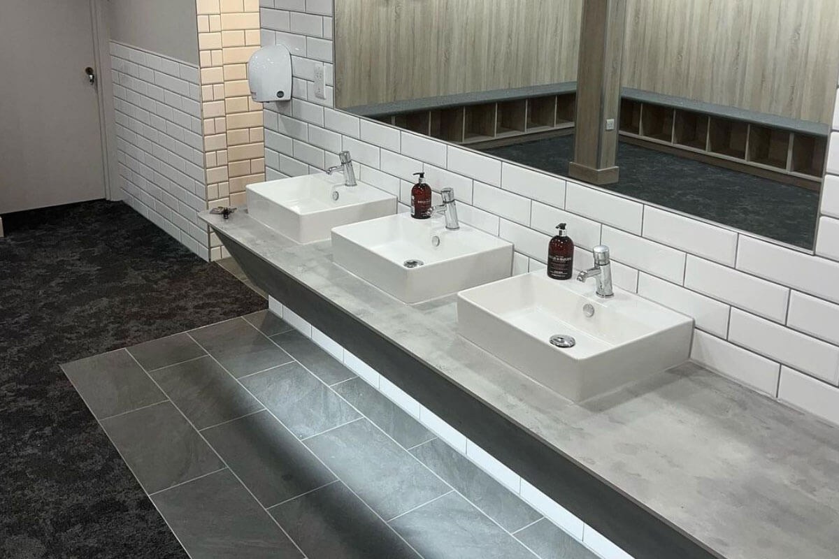 Commercial washroom vanity sealed along the tiles