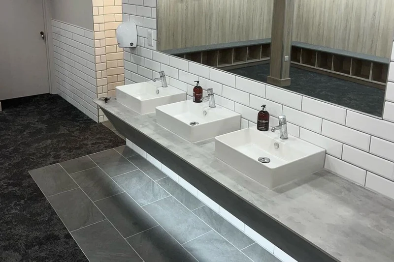 Commercial washroom vanity sealed along the tiles
